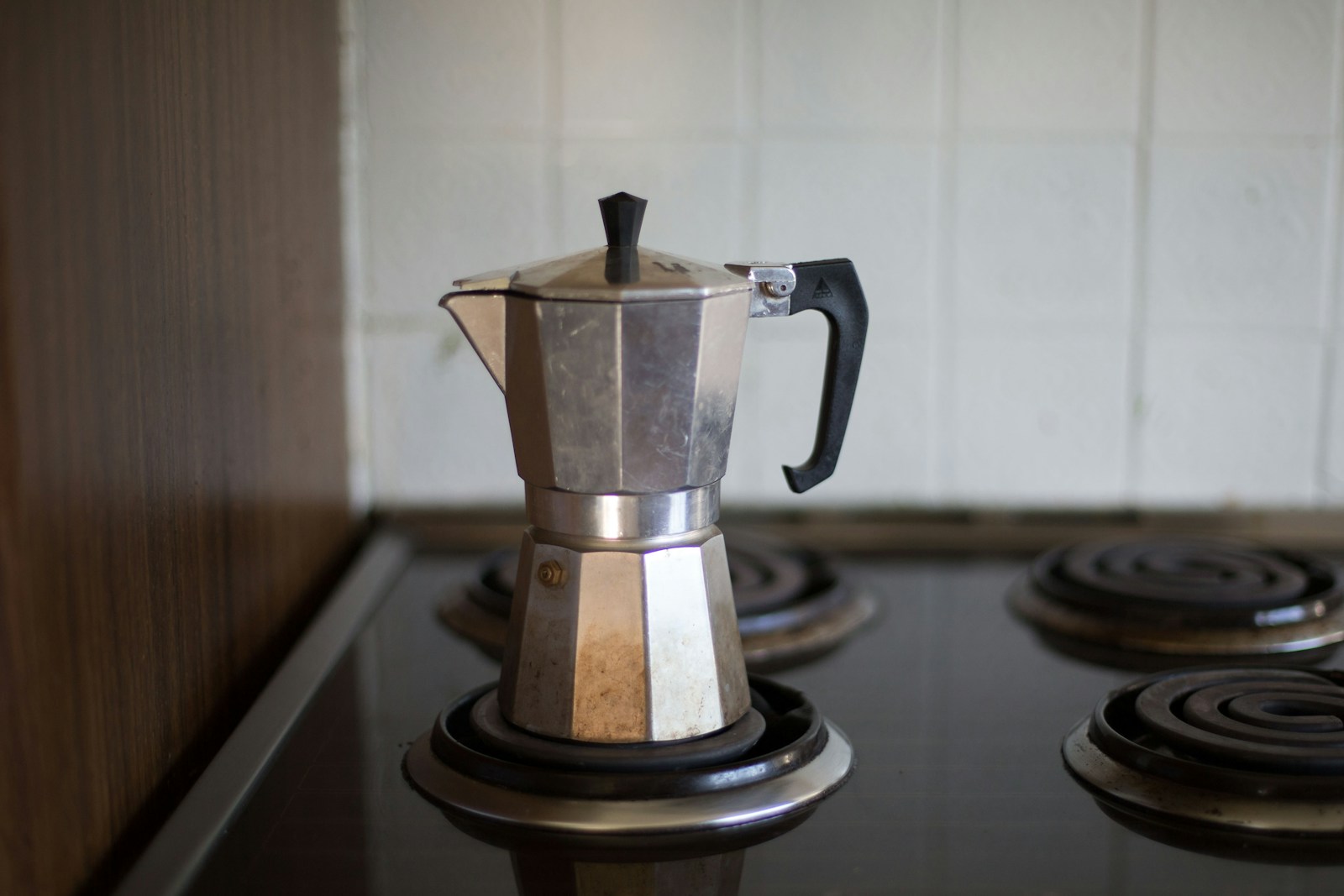 gray moka pot on electric coil stove selective focus photo